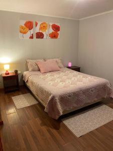 a bedroom with a bed and two paintings on the wall at Hostal El Boldal Marchigüe in Marchihue