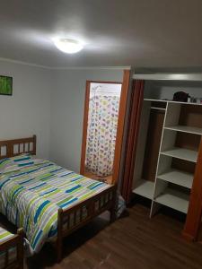 a bedroom with a bed and a ladder and a window at Hostal El Boldal Marchigüe in Marchihue