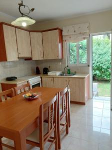 a kitchen with a wooden table and wooden chairs at Irini's Villa in Argostoli
