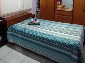 a bed with a blanket on top of it at Casa da JEANI CLEIDI in Rosário do Sul