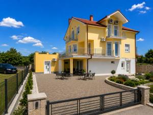 a yellow house with a patio in front of it at Grabovica Sobe-Blue Lake Luxury Rooms in Grabovica +20 photos
