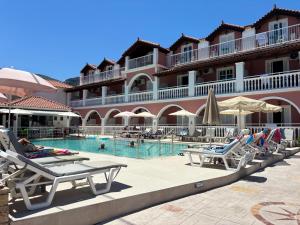 a hotel swimming pool with lounge chairs and umbrellas at Giannis Studios in Alykes