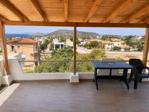 a patio with a table and a laptop on it at Panorama in Porto Rafti +8 photos