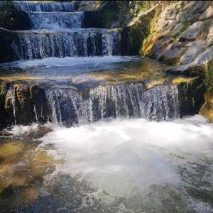 a waterfall in the middle of a river at Apartment Katzensilber in Rothenthurm