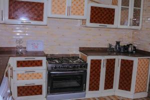 a kitchen with white cabinets and an oven at Villa Abo Ishak in Luxor
