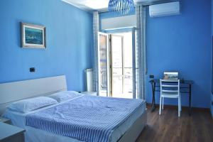 a blue bedroom with a bed and a desk at Tari Home Crotone in Crotone