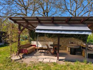 a pergola with a table and a bench and a grill at Podchlumský mlýn in Semechnice
