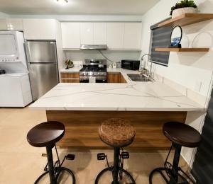 a kitchen with two bar stools and a counter top at Casa Costa Azul in Las Dos Palmas