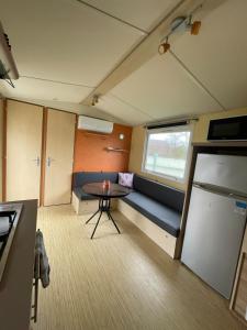 a small room with a couch and a table at Bungalow Neila in Bourbourg