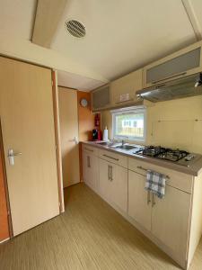 a small kitchen with a sink and a stove at Bungalow Neila in Bourbourg +2 photos