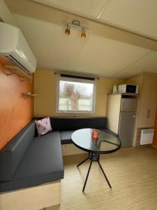 a small room with a table and a couch at Bungalow Neila in Bourbourg