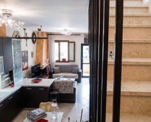 a kitchen and living room with a couch and stairs at Aqua Mare Seaside Experience in Pyrgadikia