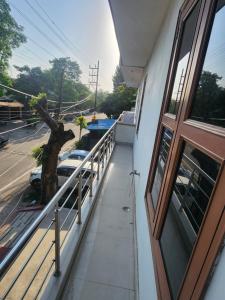 a balcony of a building with a window and a tree at Private Duplex Stay with Open Terrace in Meerut