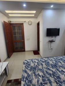 a bedroom with a bed and a tv on the wall at Private Duplex Stay with Open Terrace in Meerut