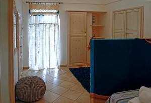 a living room with a blue wall and a window at Dammuso Terra e Mare in Kamma