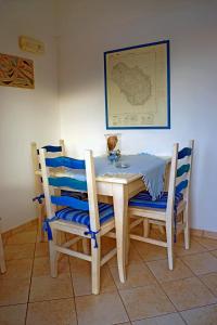 a dining room table with two chairs and a table and a picture at Dammuso Terra e Mare in Kamma