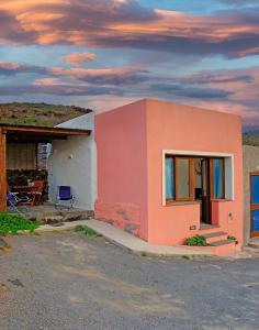 a small house with a sunset in the background at Dammuso Terra e Mare in Kamma +6 photos