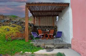 a patio with two chairs and a table in a building at Dammuso Terra e Mare in Kamma