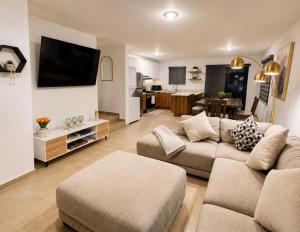 a living room with a couch and a tv at Casa Costa Azul in Las Dos Palmas