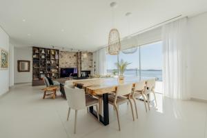 a dining room with a large table and chairs at Villa Paschalia,Sea View, Pool, Gym, Sleeps 10 in Mikonos