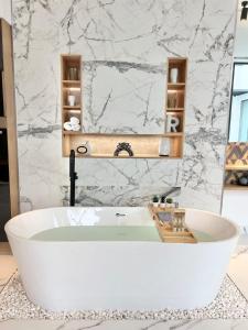 a bath tub in a bathroom with a marble wall at Rosella Chalet 2 in Jabal Al Akhdar +17 photos
