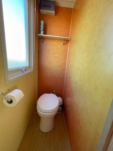 a small bathroom with a toilet and a window at Chloe Bungalow in Bourbourg