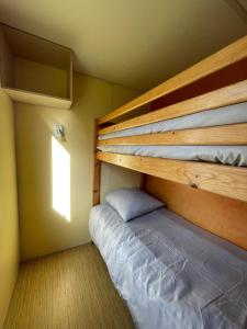 a bedroom with two bunk beds and a window at Chloe Bungalow in Bourbourg