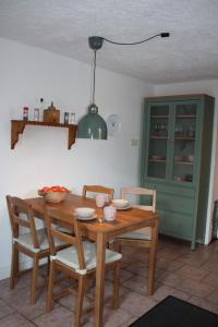 a dining room table with chairs and a green cabinet at Kleine Auszeit Blumenthal in Ferdinandshof
