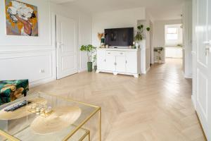 a living room with a glass table and a tv at Apartament nad bulwarem in Lidzbark Warmiński
