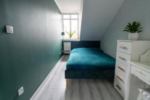 a small bedroom with a blue bed and a window at Apartament nad bulwarem in Lidzbark Warmiński +10 photos