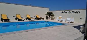 a group of chairs and a swimming pool at Solar da Pedra in Paços de Ferreira