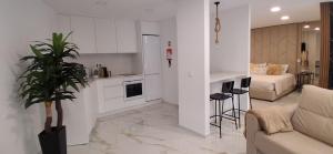 a white kitchen with a couch and a living room at Solar da Pedra in Paços de Ferreira
