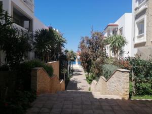 an alley between two buildings with palm trees at Al Hoceima Hay Bades Villa in Al Hoceïma