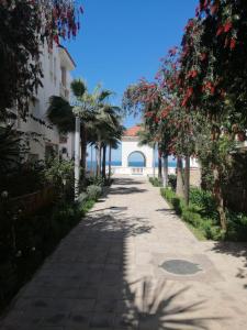 a walkway in front of a building with trees at Al Hoceima Hay Bades Villa in Al Hoceïma