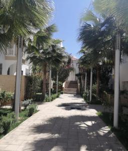 a sidewalk with palm trees in front of a building at Al Hoceima Hay Bades Villa in Al Hoceïma +65 photos