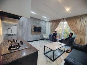 two men sitting in a living room with a table at Snow Stones in Khaira Gali