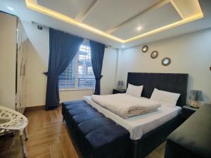 a bedroom with a large bed and a blue couch at Snow Stones in Khaira Gali