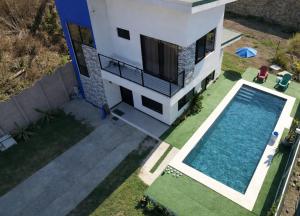 an aerial view of a house with a swimming pool at Casa Colibrí Playa Blanca in Paquera +20 photos