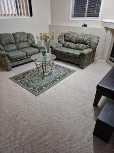a living room with two couches and a coffee table at Modern Basement Suit west side with Room 4 in Edmonton