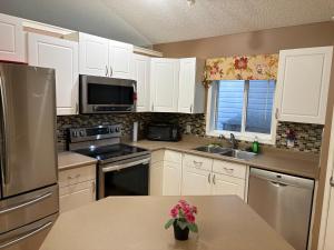 a kitchen with white cabinets and stainless steel appliances at Modern Basement Suit west side with Room 4 in Edmonton