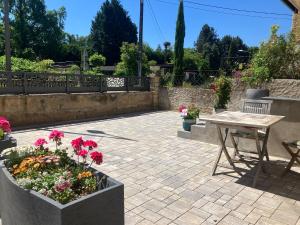 a patio with a wooden table and flowers at Le Croissant de Lune in Ingersheim