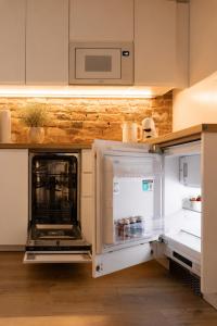 a kitchen with an open refrigerator and a microwave at Jainty Apartments Bytom in Bytom