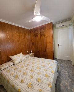 a bedroom with a bed and a ceiling fan at Ático vistas al mar in Cullera