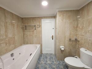 a bathroom with a tub and a toilet and a sink at Ático vistas al mar in Cullera +8 photos