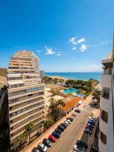 a tall building with cars parked in a parking lot at Ático vistas al mar in Cullera