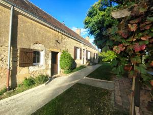 an alleyway between two old stone buildings at Maison d'hôtes Le Rancher in Teloché