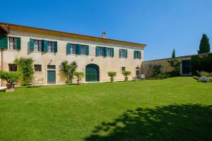 a large building with green doors and a yard at Villa Cristani in Pedemonte