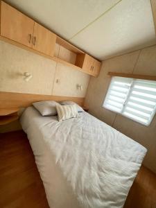 a bedroom with a large white bed with a window at Bungalow Katalina in Bourbourg