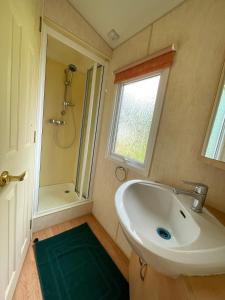 a bathroom with a sink and a shower and a window at Bungalow Katalina in Bourbourg