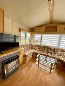 a large living room with a couch and a fireplace at Bungalow Katalina in Bourbourg +3 photos